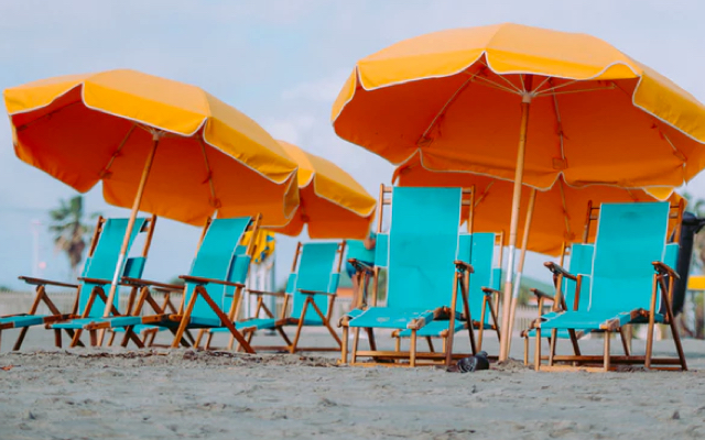 blue seats and orange umbrella on sea beach